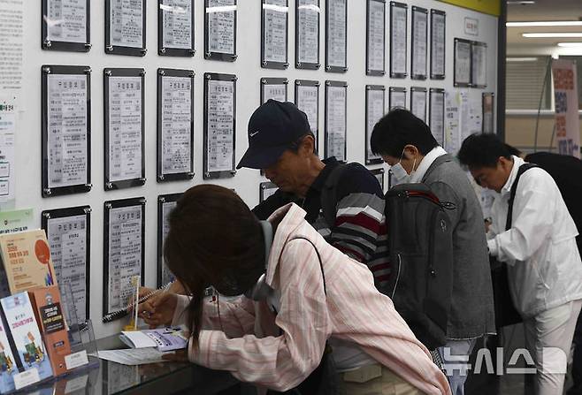 [서울=뉴시스] 김근수 기자 = 14일 서울 마포구 서부고용복지플러스센터 일자리 정보 게시판 앞에서 구직자들이 이력서를 작성하고 있다. 2025.05.14. ks@newsis.com