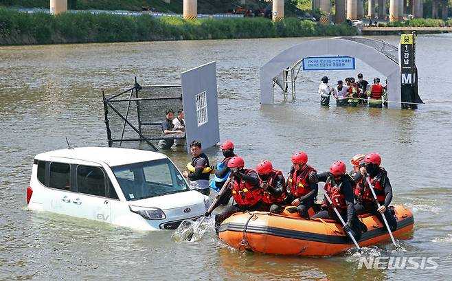 [서울=뉴시스] 김금보 기자 = 지난해 5월 31일 오후 서울 송파구 탄천공영주차장 수변 일대에서 열린 '2024년 강남구 안전한국훈련'에서 소방대원들이 강남역, 반지하, 전기차 등 도심호우·침수피해 발생 상황을 가정한 긴급구조훈련을 하고 있다. 2024.05.31. kgb@newsis.com