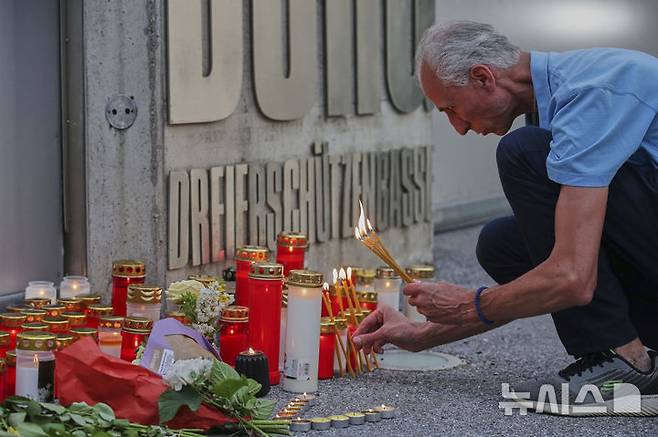 <font style="vertical-align: inherit;"><font style="vertical-align: inherit;">[그라츠=AP/뉴시스] 10일(현지 시간) 오스트리아 그라츠의 한 고등학교에서 총기 난사 사건이 발생한 후 한 남성이 학교 입구에서 희생자를 위한 촛불을 켜고 있다. 2025.06.11.</font></font>