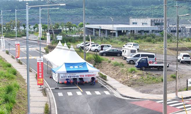 제주시 구좌읍 동복리 주민들이 제주도에 농경지 폐열지원사업 이행을 요구하며 지난 7일부터 도내 쓰레기의 대부분을 처리하는 제주환경자원순환센터의 진입로를 봉쇄했다. 10일 오전 동복리 주민들이 천막에서 제주환경자원순환센터의 입구를 통제하고 있다. 연합뉴스