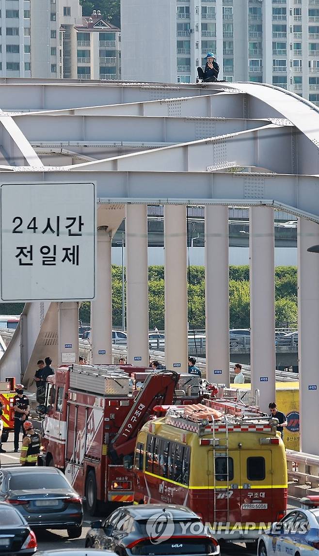 한강대교 아치 위 고공시위 (서울=연합뉴스) 신현우 기자 = 11일 서울 한강대교 아치 위에 오른 A 보육원 출신 송모 씨가 과거 보육원에서 폭력을 당한 피해자들에 대해 국가와 지방자치단체의 배상 및 보상을 촉구하며 농성을 벌이고 있다. 2025.6.11 nowwego@yna.co.kr