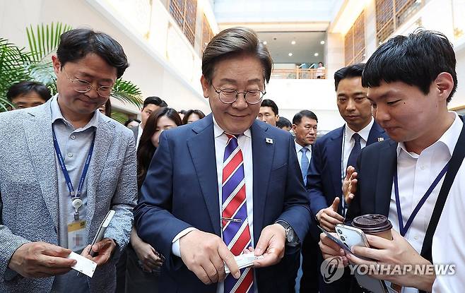 이재명 대통령과 출입기자들 (서울=연합뉴스) 한상균 기자 = 이재명 대통령이 11일 서울 용산 대통령실 기자식당에서 출입기자들과 점심식사 후 명함을 받고 있다. 2025.6.11 xyz@yna.co.kr