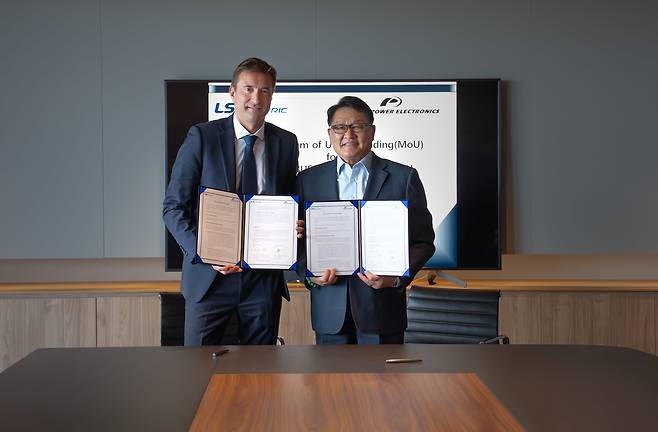 구자균(오른쪽) LS일렉트릭 회장과 데이비드 살보(왼쪽) 파워일렉트로닉스 CEO가 스페인 발렌시아에 위치한 파워일렉트로닉스 본사에서 신재생 사업 협력 MOU를 체결한 후 기념 촬영을 하고 있다./LS일렉트릭 제공