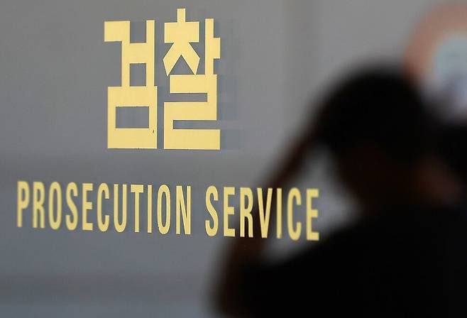 5일 서울 서초구 서울중앙지검 검찰 로고에 직원의 모습이 비치고 있다. 연합뉴스