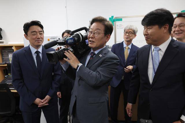 이재명 대통령이 12일 서울 용산 대통령실 영상기자실을 방문해 영상카메라를 들어 보이고 있다. 뉴시스