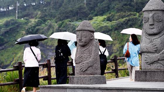 올해 첫 장맛비가 내리는 12일 오전 제주 서귀포시 대정읍 송악산 둘레길에서 우산을 쓴 관광객들이 걸어가고 있다. 뉴시스