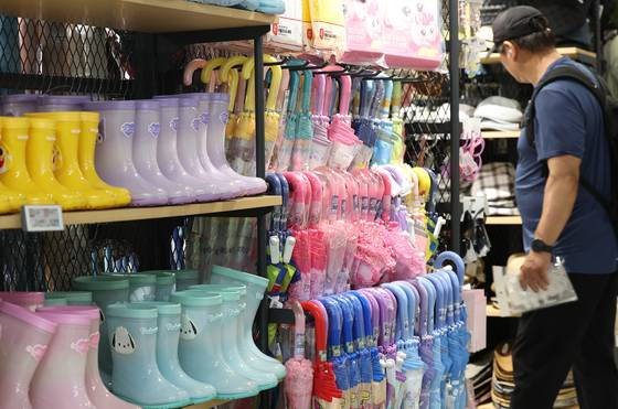 Rain boots and umbrellas are displayed at a supermarket in Seoul on June 12, as the rainy season starts with Jeju Island. [YONHAP]