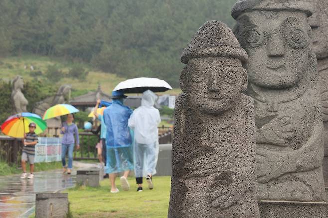 Visitors walk along a trail at Mount Songak in Daejeong-eup, Seogwipo, Jeju, on June 12 as the rainy season starts on the island. [YONHAP]