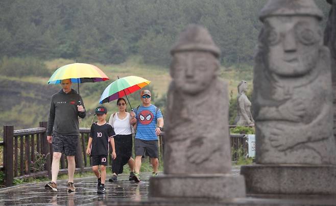 올해 첫 장맛비가 내리는 12일 오전 제주 서귀포시 대정읍 송악산 둘레길에 우산을 쓴 관광객들이 걸어가고 있다. 뉴시스