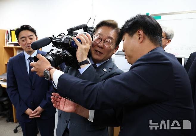 [서울=뉴시스] 최진석 기자 = 이재명 대통령이 12일 서울 용산 대통령실 영상기자실을 방문해 영상카메라를 들어 보이고 있다. 2025.06.12. myjs@newsis.com