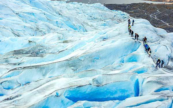 크램폰을 신고 천년의 빙하 위에 올라서서 펭귄처럼 걷는다. 트레킹 종료 즈음에 가이드가 1,000년 얼음 조각을 넣은 위스키 한 잔을 권한다. 사진 Caio Portela.