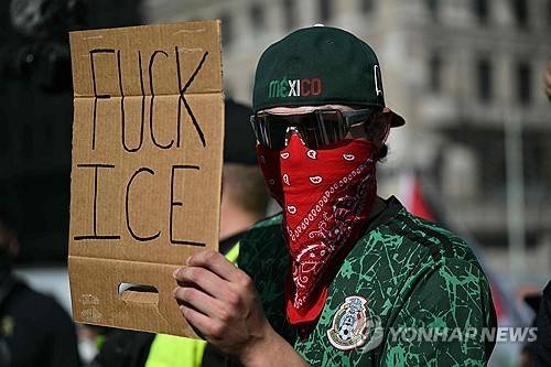 ICE 단속 항의 플래카드 든 시위 참가자 (로스앤젤레스 AFP=연합뉴스) 2025년 6월 11일(현지시간) 멕시코 모자를 쓴 한 남성이 로스앤젤레스 도심 퍼싱 스퀘어에서 이민세관단속국(ICE)을 비난하는 플래카드를 들고 있다. (Photo by RONALDO SCHEMIDT / AFP) 2025.6.12.