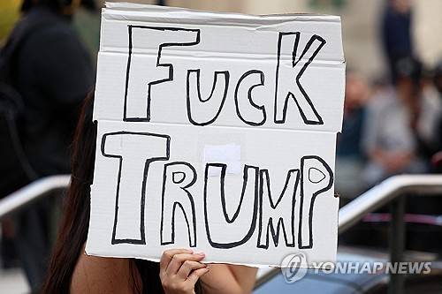 트럼프 비난 플래카드 든 뉴욕 시위 참가자 (뉴욕 AFP=연합뉴스) 2025년 6월 11일 미국 뉴욕에서 열린 이민세관단속국(ICE) 단속 항의 시위에서 한 시위 참가자가 도널드 트럼프 대통령을 비난하는 플래카드를 들고 있다. (Photo by CHARLY TRIBALLEAU / AFP) 2025.6.12.