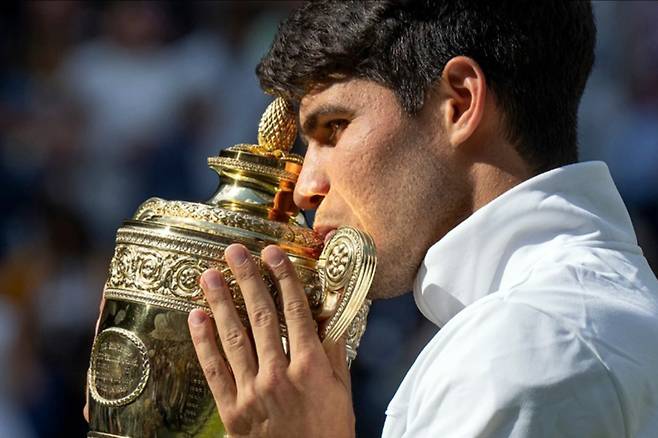 카를로스 알카라스가 지난해 윔블던 남자단식 2연패 달성 뒤 우승트로피에 입맞춤을 하고 있다. 사진/윔블던