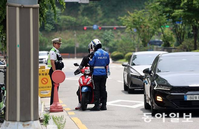 9일 오전 경기 화성시에서 교통경찰이 신호를 위반한 오토바이 운전자를 단속하고 있다. 화성=장승윤 기자 tomato99@donga.com