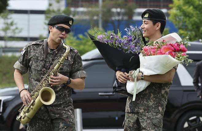 육군 현역 복무를 마치고 만기 전역한 그룹 방탄소년단(BTS) 알엠(RM, 왼쪽)과 뷔가 지난 10일 강원 춘천시 신북읍체육공원에서 열린 팬과의 만남 행사에서 색소폰을 연주하고 있다. EPA
