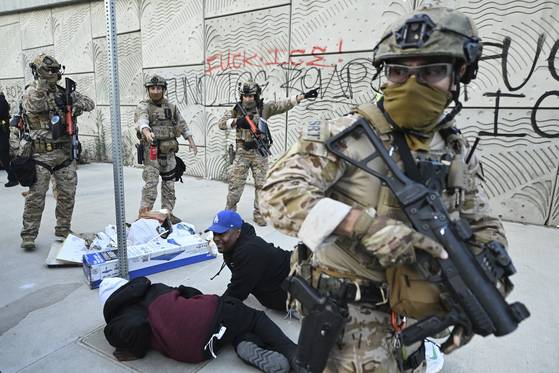 미국 세관국경보호국 요원들이 12일(현지시간) 로스앤젤레스에서 시위대를 해산시키고 있다. AP=연합뉴스