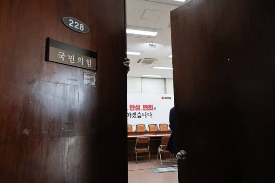 5일 오전 국회에서 열릴 예정이던 국민의힘 비상대책회의가 취소되자 한 당직자가 회의실 문을 닫고 있다. 임현동 기자