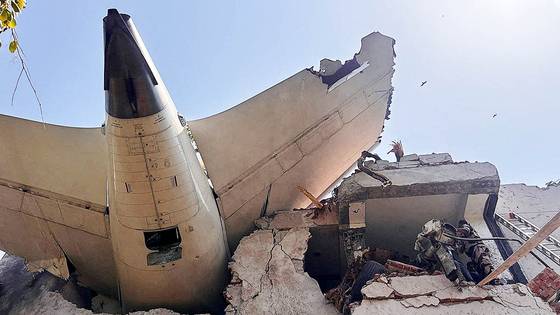 12일(현지시간) 242명을 태운 인도 항공사 에어인디아의 AI171 여객기가 인도 구자라트주 아메다바드 국제공항 인근 거주 지역에 추락했다. 여객기의 꼬리 부분이 추락 후 충돌해 건물에 박혀있다. AFP=연합뉴스