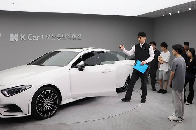 성강훈 케이카 오산동탄지점 판매실장이 학생들에게 차량 진단 과정을 설명하고 있다. [케이카 제공]