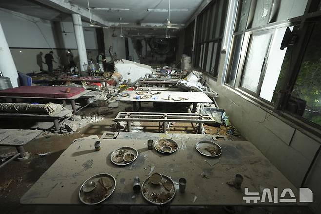 [아마다바드=AP/뉴시스] 12일(현지 시간) 인도 구자라트주 아마다바드에서 여객기가 추락하며 기체 꼬리 부분이 충돌한 건물 꼭대기 내부 구내식당이 파손돼 있다. 이날 오후 아마다바드 공항에서 이륙한 영국행 에어인디아 AI171편 여객기가 추락해 탑승자 242명 가운데 1명을 제외한 전원이 숨졌으며, 추락 현장의 학생 등 약 50명도 사망한 것으로 전해졌다. 2025.06.13.