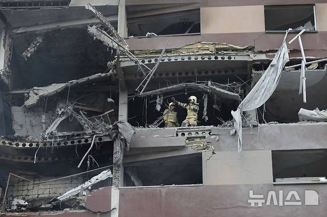 [테헤란=AP/뉴시스] 13일(현지 시간) 이란 테헤란 북부의 주거 단지 폭발 현장에서 소방관들이 구조 작업을 벌이고 있다. 이스라엘방위군(IDF)은 이날 새벽 이스라엘이 이란의 핵·군 시설에 대한 선제타격을 개시했다고 성명을 통해 밝혔다. 2025.06.13.