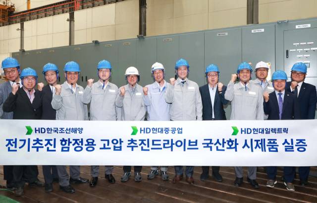 김성준(왼쪽 여덟 번째) HD한국조선해양 대표와 주원호(〃 다섯 번째) HD현대중공업 특수선 사업대표, 김영기(〃 일곱 번째) HD현대일렉트릭 대표가 전기추진 함정용 고압 추진 드라이브 국산화 시제품 실증식에서 기념 촬영을 하고 있다. 사진 제공=HD현대