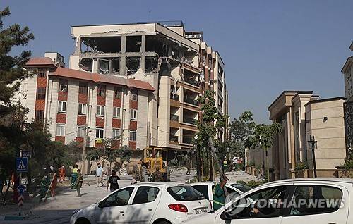 이스라엘 공습으로 파괴된 테헤란의 건물 (테헤란 AFP=연합뉴스) 2025년 6월 13일 이스라엘군 공습으로 파괴된 이란 테헤란 시내 건물 앞에 사람들이 모여 있다. (Photo by ATTA KENARE / AFP) 2025.6.13.