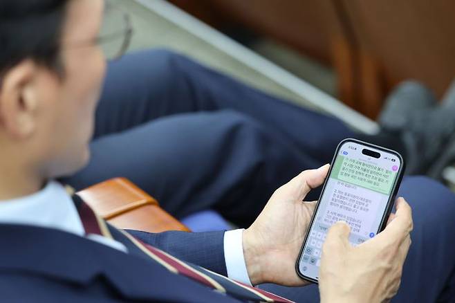 김민석 국무총리 후보자가 13일 국회에서 열린 제2기 원내대표 선출 의원총회에 참석해 최근 의혹 관련 글을 작성하고 있다. ⓒ뉴시스