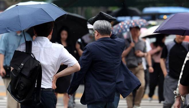 [서울=뉴시스] 추상철 기자 = 퇴근길 장맛비가 내린 13일 오후 서울 종로구 세종대로사거리에서 우산을 준비하지 못한 시민이 발걸음을 재촉하고 있다. 2025.06.13. scchoo@newsis.com /사진=뉴시스