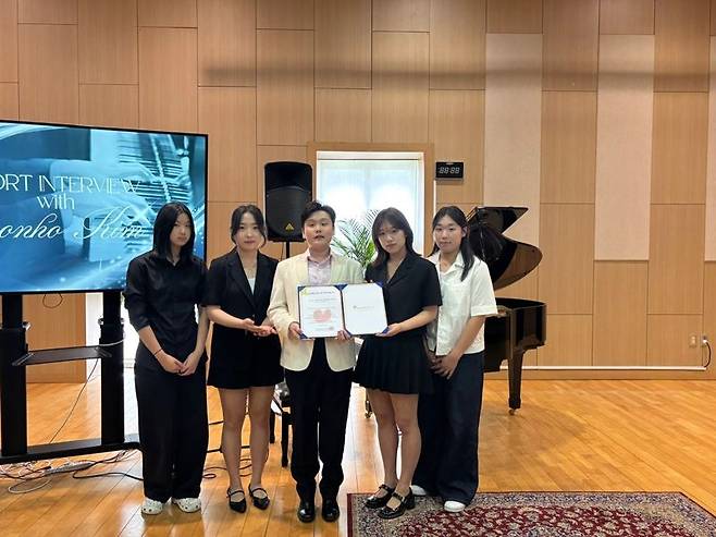 제주 영어교육도시의 국제학교 노스런던컬리지에잇스쿨 제주에서 14일 열린 연주회에서 김건우 피아니스트(왼쪽 세번째)와 참석자들이 기념촬영 하고 있다.