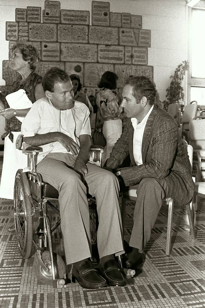 베냐민 네타냐후(오른쪽)가 엔테베 작전에 투입됐다가 영구 장애를 얻은 대원 소린 헤르시코와 1986년 7월 2일 만나 대화하고 있다. [이스라엘 정부 공보실/게티이미지]