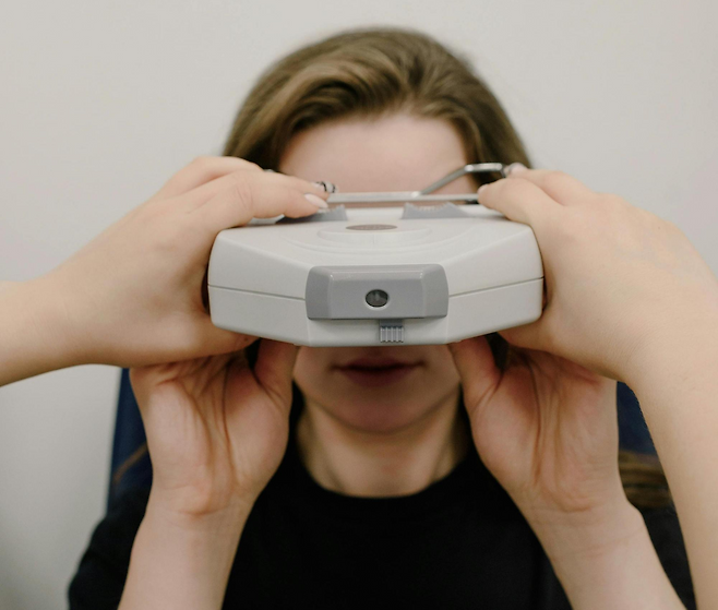 검사 기기를 눈에 대고 있는 여성