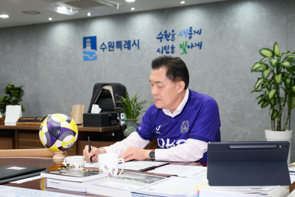 프로축구 K리그1 수원FC의 이재준 구단주가 ‘1호선 더비’ 공약을 지키기 위해 FC안양의 보라색 유니폼을 입고 집무를 보고 있다. /이재준 시장 SNS 캡쳐