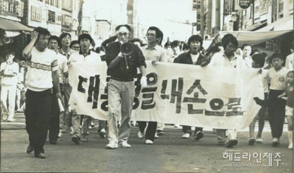 1987년 6월, 서귀포시 지역 거리시위. '대통령을 내 손으로'라는 현수막과, 선두에서 손 마이크를 들고 있는 진희종씨(제주평생교육장학진흥원 원장)의 모습이 눈길을 끈다. 그는 1980년 5월27일 새벽 계엄군의 전남도청 진압 당시 마지막까지 남아 저항하다 체포됐던 최후의 시민군 중 한명(당시 전남대 1학년, 이 사건으로 제적)이기도 하다.&nbsp; (사진=서귀포 6월민주항쟁 정신계승사업회)