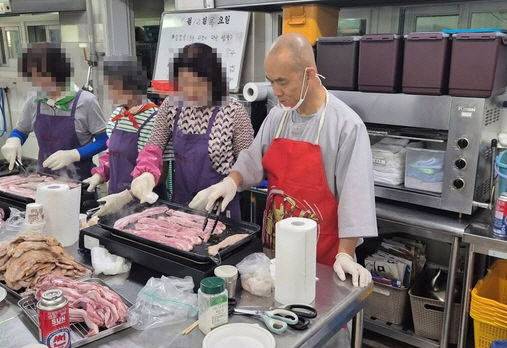 문빈정사 주지 법공 스님이 까리따스수녀원에서 운영하는 성요셉 사랑의 식당에서 삼겹살을 굽고 있다. (사진=뉴시스)