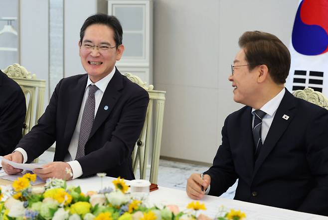 이재명 대통령이 13일 서울 용산 대통령실에서 열린 6경제단체·기업인 간담회에서 이재용 삼성전자 회장(사진 왼쪽)의 발언을 듣던 중 함께 미소짓고 있다. (사진=연합뉴스)