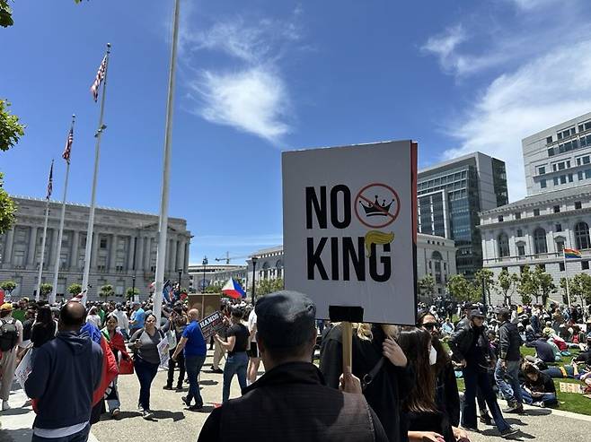 14일(현지시간) 미국 샌프란시스코 시청 광장에서 열린 '노킹스'(No Kings·왕은없다) 시위에서 한 시위자가 '노킹'(왕은 없다) 이라는 팻말을 들고 시위하고 있다.사진=홍창기 기자