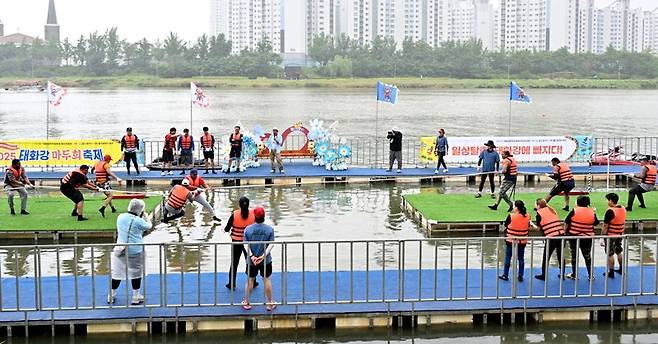 2025 태화강 마두희 축제 '수상 줄다리기'에 참가한 외국인 방문객들이 물에 빠지지 않으려고 아슬아슬한 승부를 펼치고 있다. 울산 중구 제공