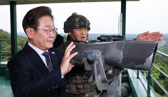 이재명 대통령이 13일 경기도 연천군 육군 25사단 비룡전망대에서 한기성 사단장의 설명을 들으며 망원경으로 북측 지역을 보고 있다. 연합뉴스