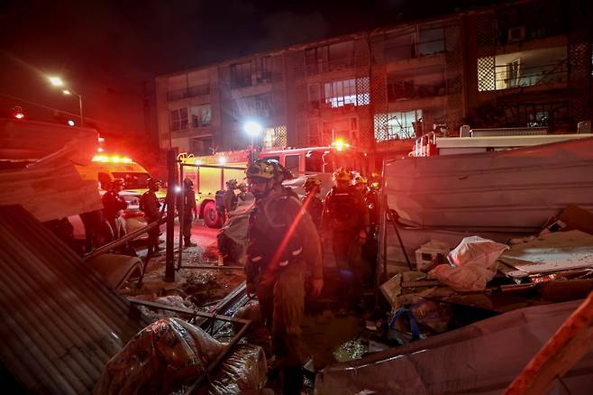 이스라엘 구조팀이 15일(현지시간) 이스라엘 텔아비브 인근 바트얌의 주거용 건물에 이란의 탄도 미사일이 충돌한 현장에서 구조 작업을 하고 있다. 사진=EPA