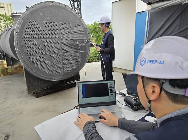 Engineers conduct defect testing on a heat exchanger using an automated AI solution co-developed by SK Innovation and Deep AI at the SK Innovation Ulsan Complex. (SK Innovation)