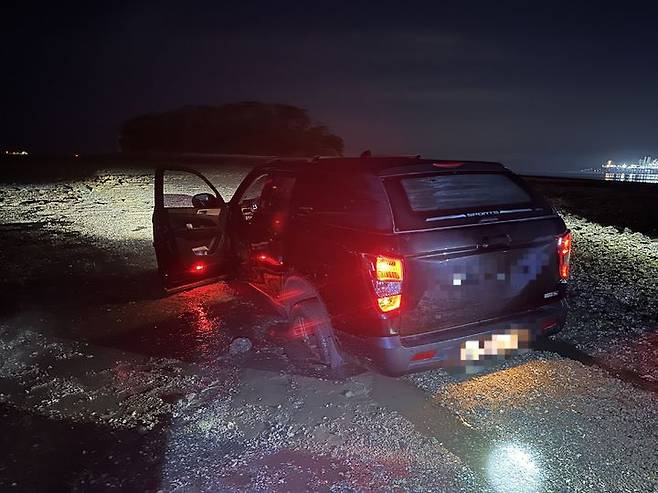 [서산=뉴시스] 15일 새벽 2시7분께 서산시 대산읍 대죽리 숙호지 인근 갯벌에서 SUV차량이 빠져 움직이지 못하고 있다. (사진=평택해양경찰서 제공) 2025.06.15. photo@newsis.com *재판매 및 DB 금지