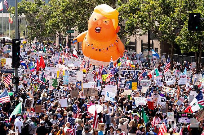 [로스앤젤레스=AP/뉴시스] 14일(현지 시간) 미 캘리포니아주 로스앤젤레스에서 ‘노 킹스(No Kings)’ 시위 참가자들이 각종 손팻말을 들고 행진하고 있다. 미 전역에서 트럼프 대통령의 권위주의적 국정운영을 비판하는 '노 킹스' 시위가 이어졌다. 2025.06.15.