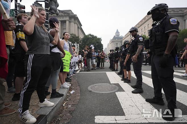 [워싱턴=AP/뉴시스] 미 육군 창설 250주년 기념 군사 퍼레이드와 도널드 트럼프 대통령의 79번째 생일이 겹친 14일(현지 시간) 워싱턴에서 반트럼프 시위대가 경찰과 대치하고 있다. 미 전역에서 트럼프 대통령의 권위주의적 국정운영을 비판하는 '노 킹스(No Kings)' 시위가 이어지고 있다. 2025.06.15.