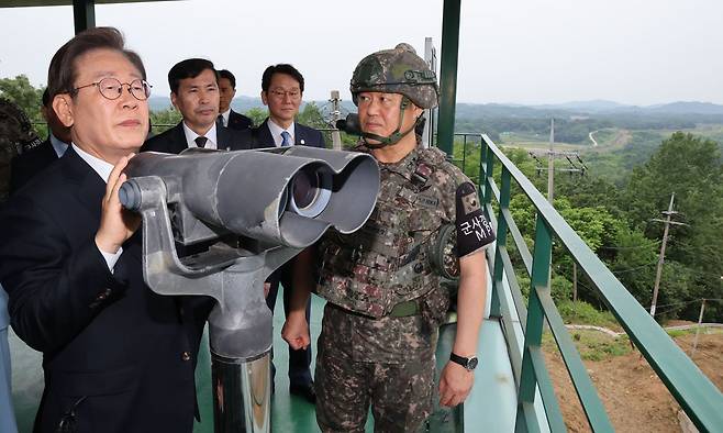 이재명 대통령이 지난 13일 경기 연천군 25사단 비룡전망대를 방문해 군 관계자의 설명을 들으며 북측을 살펴보고 있다. 대통령실사진기자단