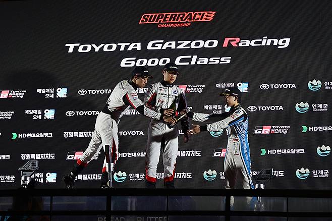 포디엄에 오른 노동기, 이창욱, 그리고 헨잔 료마가 샴페인 세레머니를 하고 있다. 사진: 김학수 기자