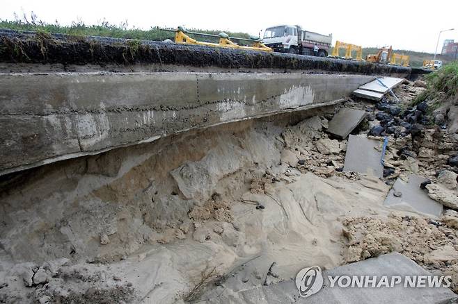 모래 위에 개설한 월정 해안도로가 2004년 폭우 피해로 무너진 모습 [연합뉴스 자료 사진]