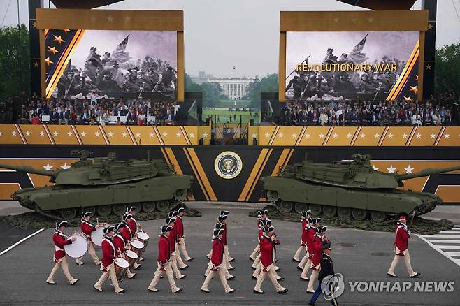 미 육군 창설 250주년 열병식 (워싱턴 AFP=연합뉴스) 14일(현지시간) 미국 워싱턴DC에서 열린 미 육군 창설 250주년 기념 열병식에서 독립전쟁 당시 군복을 입은 군인들이 도널드 트럼프 대통령이 있는 무대 앞으로 행진하고 있다. 2025.6.14