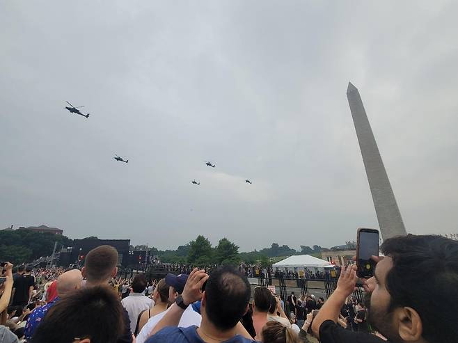 美 육군 창설 250주년 열병식 (워싱턴=연합뉴스) 조준형 특파원 = 14일(현지시간) 미국 워싱턴 DC에서 미국 육군 창설 250주년 기념 열병식이 열렸다. 
 워싱턴 기념탑 옆으로 헬기가 날아가자 청중들이 휴대전화로 촬영하고 있다. 2025.6.15 jhcho@yna.co.kr